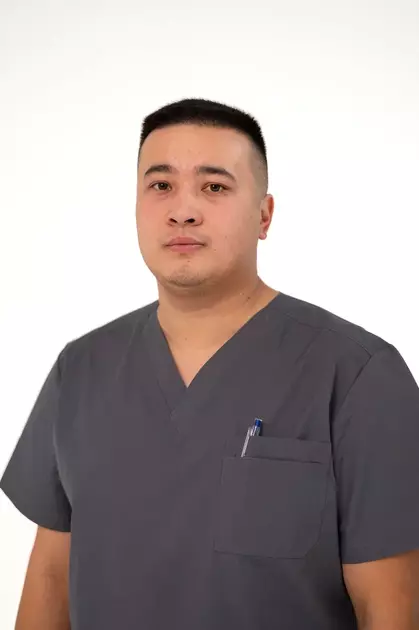 Фельдшер Зулкашев Данияр Нурланович в серой медицинской рубашке