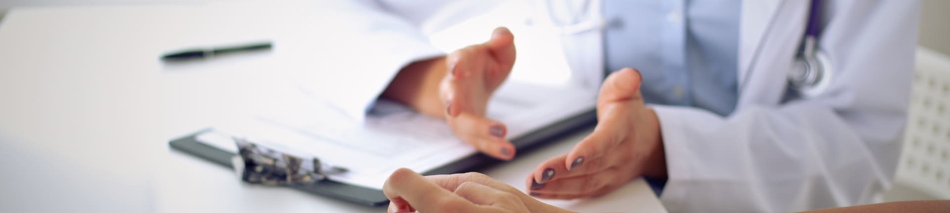 Клиника лечения химических зависимостей в Конаково Врач за рабочим столом беседует с пациентом