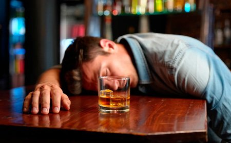 Мужчина лежит на столе с бокалом в руках