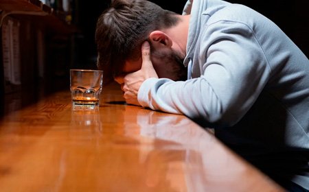 Мужчина склонил голову на барной стойке